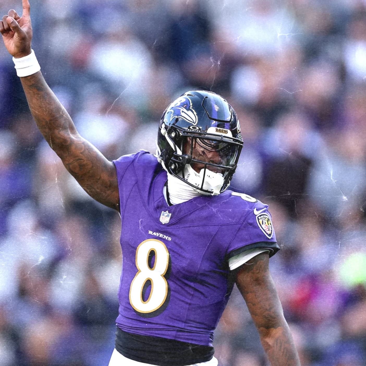 Lamar Jackson of the Baltimore Ravens points to the sky in the purple home uniform.