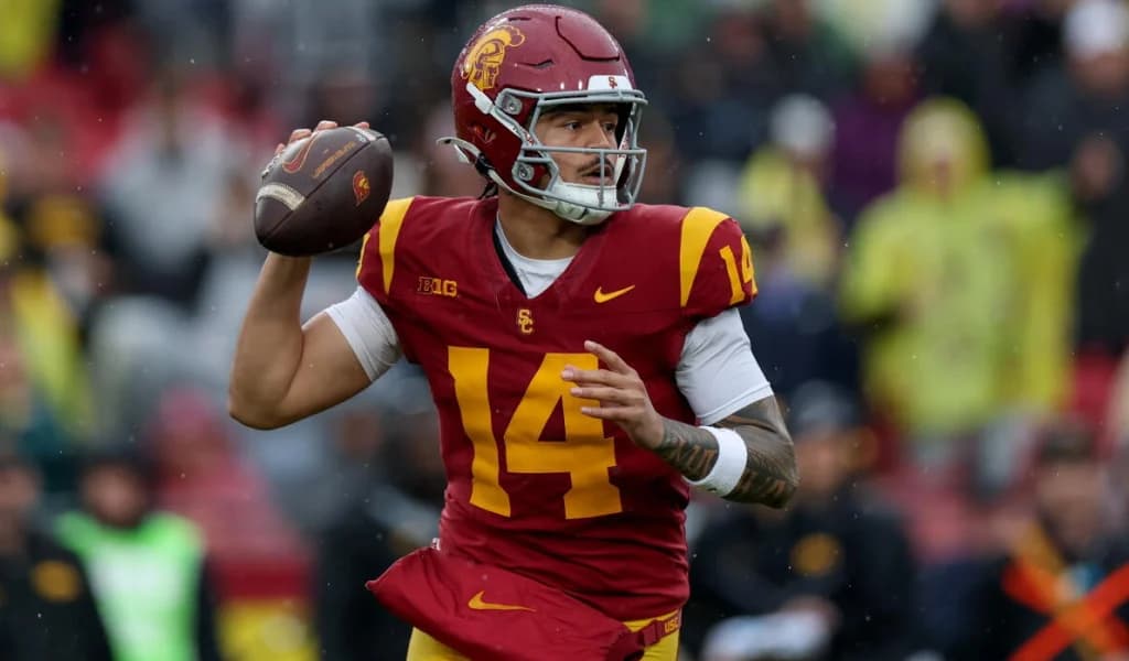 A USC quarterback in the cardinal number 14 jersey fires a pass.