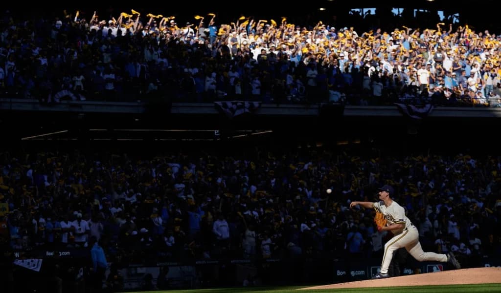 Brewers pitcher delivers under the lights as fans wave rally towels