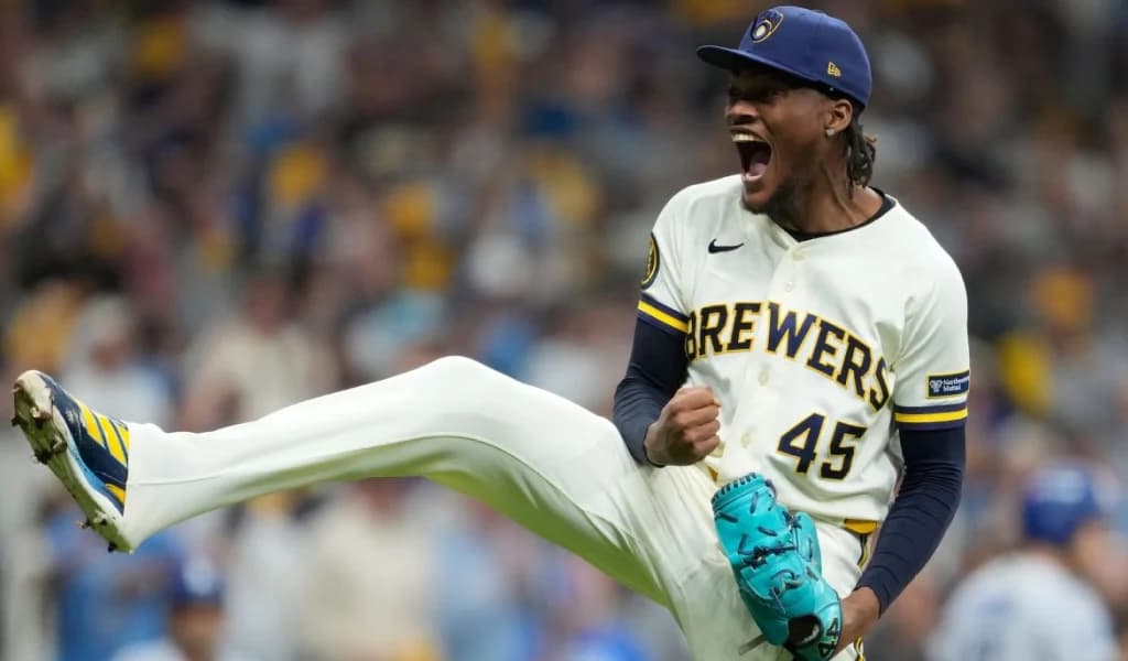 A Brewers pitcher in the number 45 home uniform kicks his leg up in a fired-up celebration.