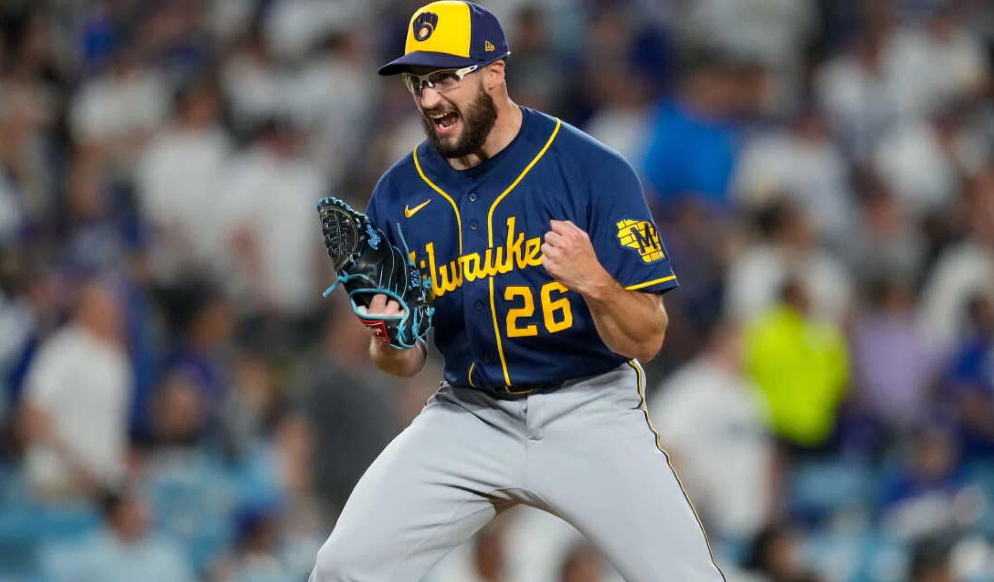 A Milwaukee Brewers pitcher in the navy number 26 jersey celebrates an out.